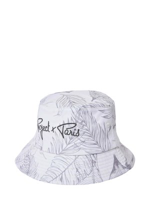 Witte bucket hat met lichtgrijs tropisch bladmuster en zwarte geborduurde tekst "Project x Paris" aan de voorkant.