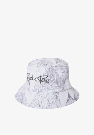 Witte bucket hat met lichtgrijs tropisch bladmuster en zwarte geborduurde tekst "Project x Paris" aan de voorkant.