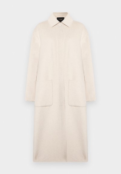 Beige ullkappa med krage, frontknäppning, två stora fickor och ärmar i armbågs längd. Enkel, rak silhuett.