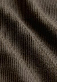 Tamsi ribuota medžiaga, pasižyminti tekstūruota paviršiaus su mažomis vertikaliomis linijomis. Medžiaga atrodo minkšta ir lanksči, tinkama įvairioms paskirtims.