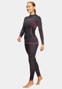 Dwuczęściowy piankowy kombinezon w kolorze czarnym i ciemnoszarym z różowymi akcentami. Posiada długie rękawy, dopasowany krój oraz teksturowane panele. Gładki materiał.