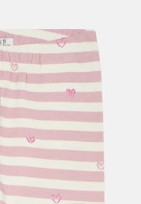 Črtaste pajkice v svetlo roza in beli barvi z elastičnim pasom. Opremljene z majhnimi, bleščečimi roza srčastimi aplikacijami. Mehki bombažni material.