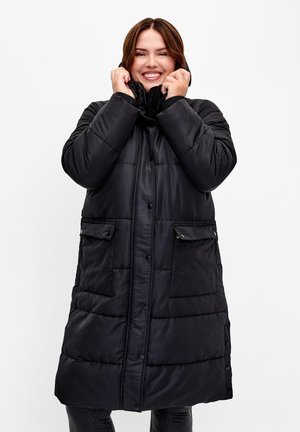 Manteau d'hiver noir avec une texture matelassée, des boutons-pression, deux poches avant et un col haut. Le matériau semble brillant et isolé.