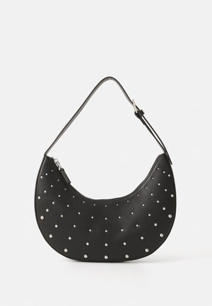 Sac à main en cuir noir avec une forme arrondie, orné de clous en argent, doté d'une fermeture éclair et d'une seule sangle ajustable.