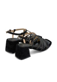 Sandali con tacco in suede nero con cinturini decorativi, dotati di accenti di strass, punta aperta e tacco quadrato chunky.