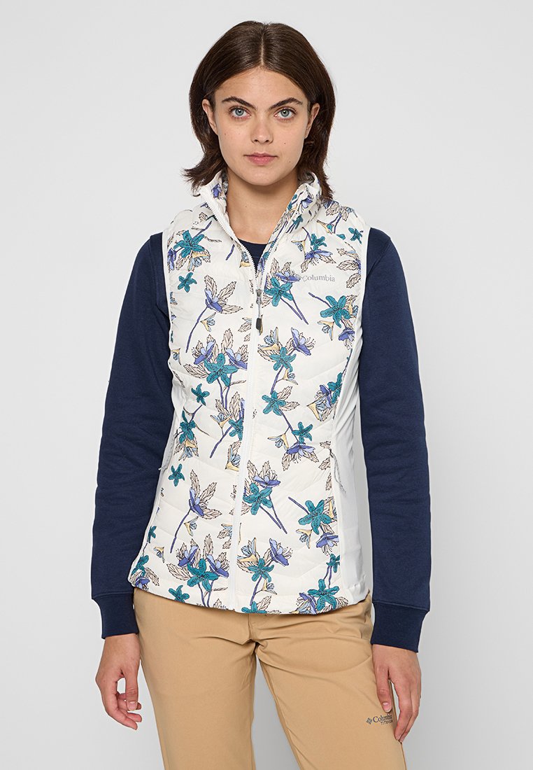 Chaleco con estampado floral y parte delantera blanca que presenta flores azules y moradas; tejido lateral en color marino; cierre con cremallera y costuras detalladas.