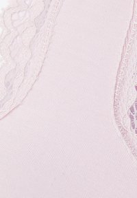 Tela de color rosa claro que muestra una textura suave y elástica, con un borde de encaje a lo largo de los bordes, presentando delicados patrones florales y un diseño con ondas.