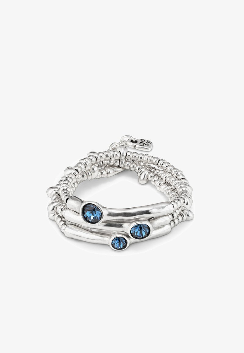Pulsera de plata de ley con un diseño en espiral, que presenta tres gemas redondas azules. Las cuentas texturizadas crean una apariencia en capas.