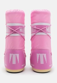 Stivali impermeabili rosa con una superficie lucida, apertura elasticizzata e branding bianco sulla parte centrale. Suola arrotondata, texture liscia.