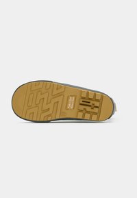 Semelle de chaussure d'enfant avec motif de bande de roulement jaune, taille 29, et étiquette "Fabriqué en Chine" au centre.