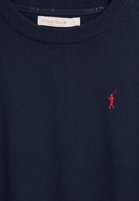 Pull en maille bleu marine avec col rond, petit logo rouge de joueur de polo sur la poitrine et étiquette « Polo Club » à l'intérieur du col.