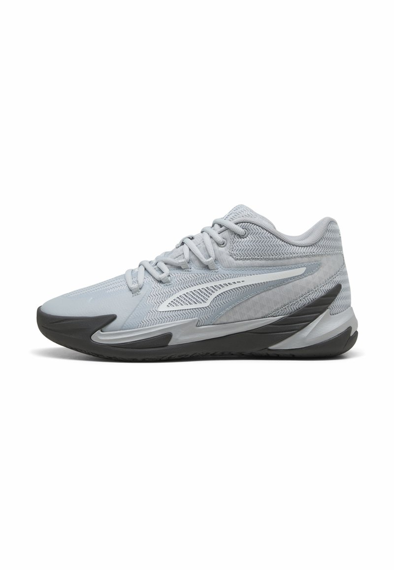 Chaussure de sport gris clair avec une tige en mesh texturé, semelle en caoutchouc gris foncé et un design épuré avec des accents renforcés.