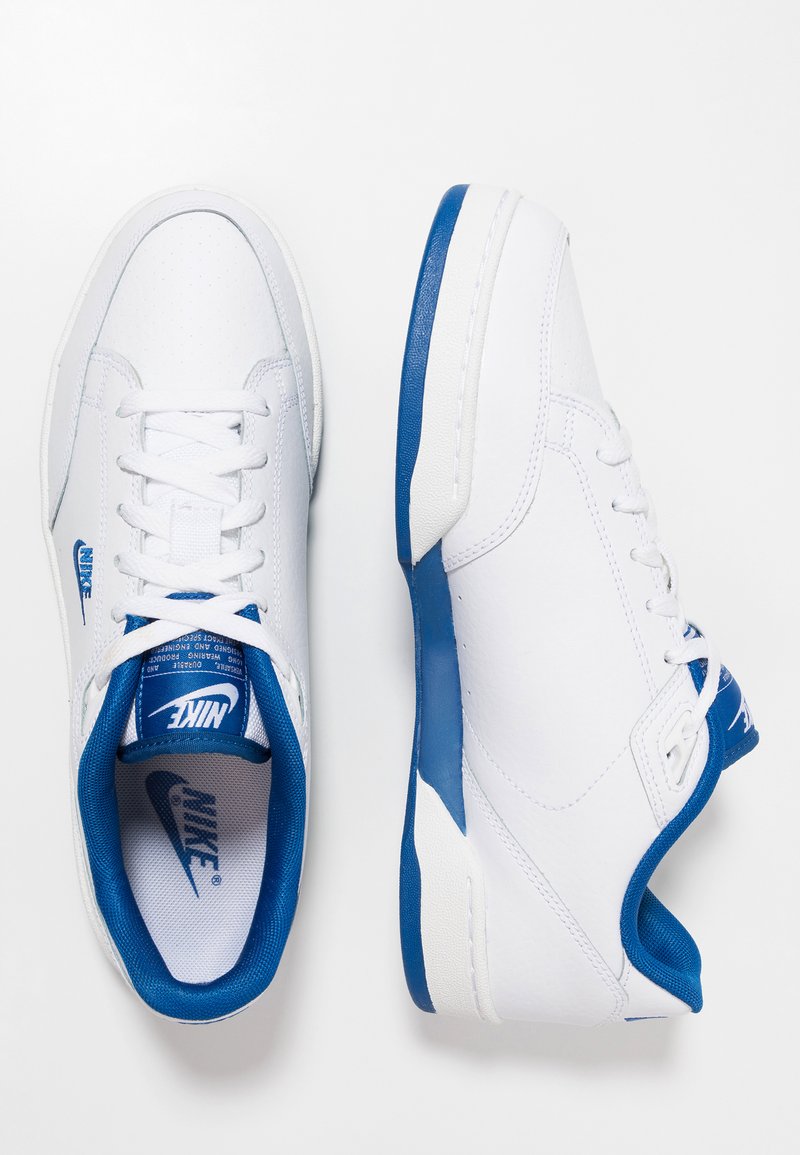 Białe skórzane sneakersy z niebieskimi akcentami i perforowanym czubkiem. Posiadają płaskie sznurówki, wyściełany kołnierz oraz logo na języku i boku.