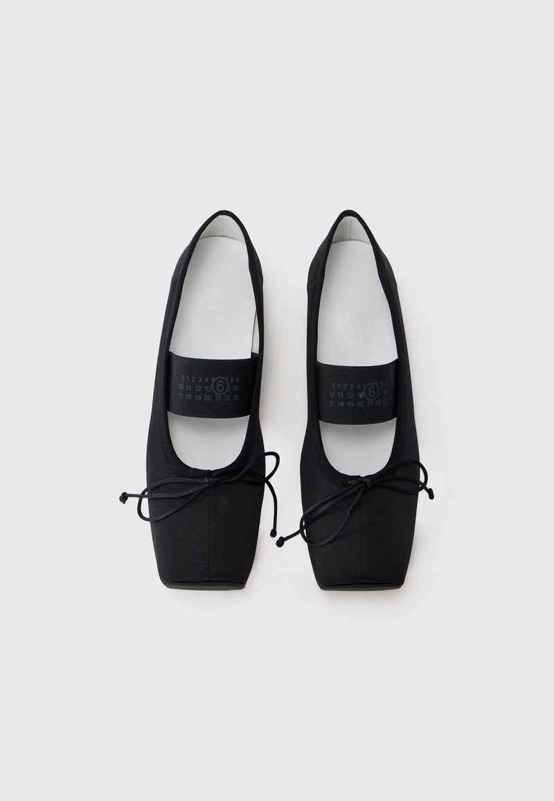 Black ballet flats made of smooth fabric with a square toe, featuring a thin lace at the front and a cushioned insole.