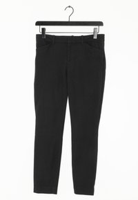Svart, smal passform byxor gjorda av ett slätt tyg, med framfickor och midjeband med bälteshällor, hängande på en svart galge.