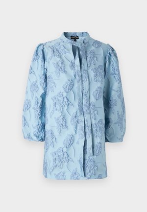 Light blue blouse featuring textured floral embroidery, puff sleeves, and a stand collar with a tie closure at the front.