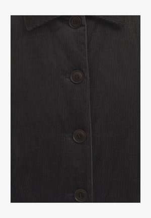 Camisa de pana oscura con una tela texturada de finas costillas verticales, cierre frontal con botones y botones redondos marrones.