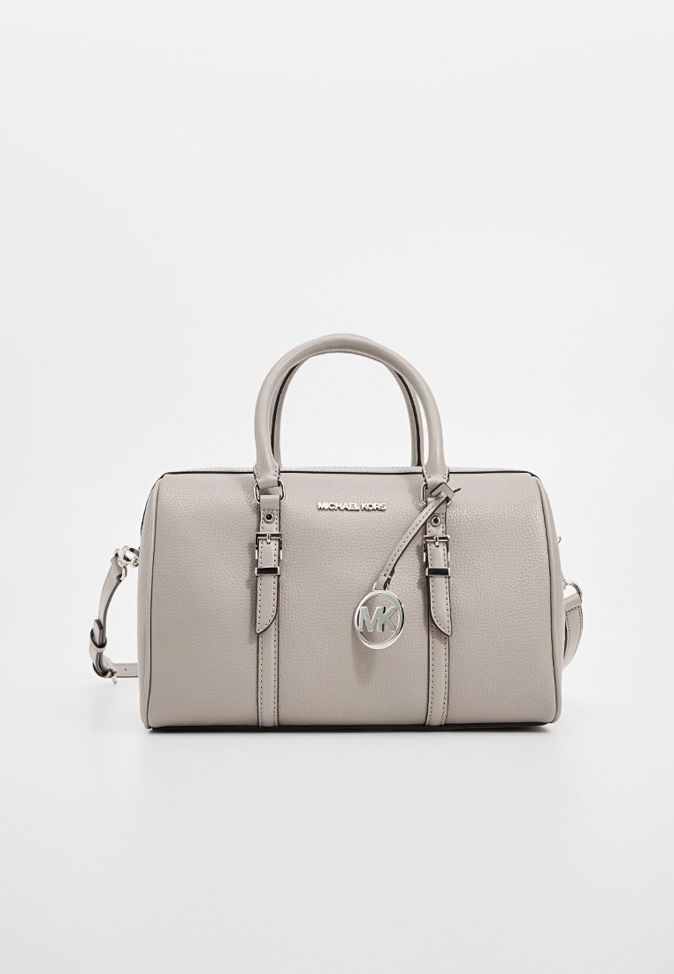 Sac à main en cuir gris avec un design structuré, deux poignées supérieures et une bandoulière réglable. Présente un pendentif en forme de logo MK et des accents métalliques en argent.