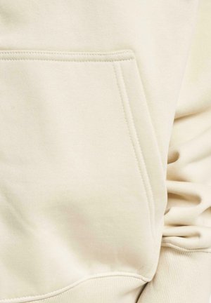 Beige hoodie made of soft fabric, featuring a kangaroo pocket and ribbed cuffs. Smooth texture with subtle stitching details.