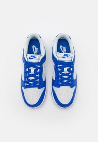 Nike sneakers featuring white leather with blue accents, perforated toe box, flat blue laces, and padded collar for comfort.