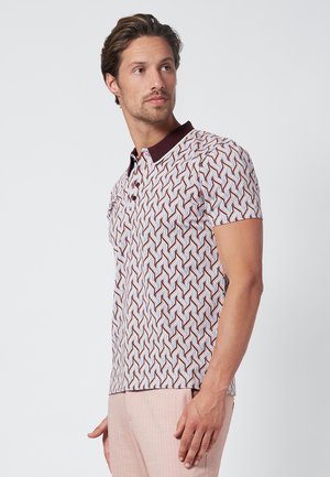 Polohemd mit geometrischem Muster in Rot, Blau und Weiß. Mit einem kastanienbraunen Kragen und kurzen Ärmeln, hergestellt aus leichtem Stoff.