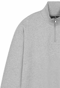 Lichtgrijze sweatshirt met een opstaande kraag en een halve ritssluiting, gemaakt van zacht materiaal, met een gladde textuur en subtiele stiksel details.