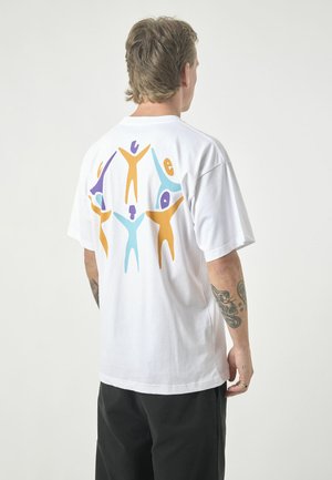 White cotton t-shirt featuring a colorful print of abstract human figures in purple, orange, yellow, and blue on the back.