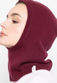 Burgundowy dziany szal z kapturem, o gładkiej fakturze i żebrowanych krawędziach, z białym logo z boku.