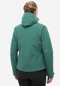 Veste imperméable verte avec un col haut et une capuche, présentant une texture lisse et un design ajusté. La vue arrière montre des lignes et des coutures épurées.