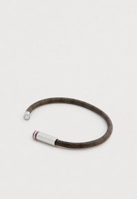 Rjava okrogla zapestnica s vzorčasto površino in srebrnim zaključkom, vgravirana z napisom "HILFIGER." Vključuje rdečo, belo in modro poudarjeno črto.