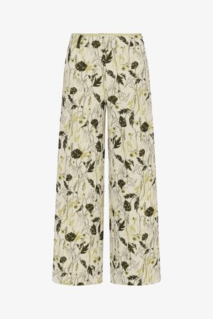 Wide-leg cream pants with green and black floral and leaf print, featuring a fitted waist and relaxed fit.