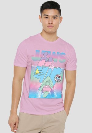 Pink cotton t-shirt featuring a graphic design of a shark, ocean scene, and the word "JAWS" in bold, colorful letters.