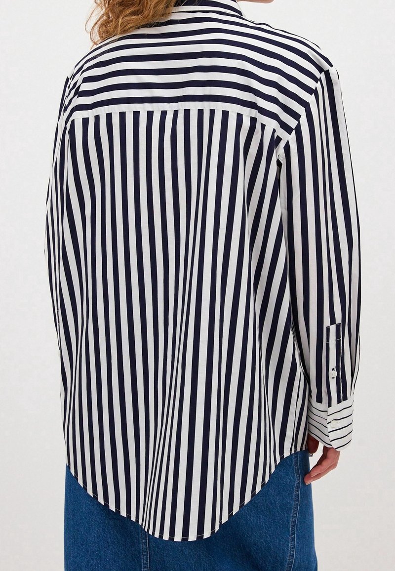 Navy and white striped shirt with a curved hem, button cuffs, and a classic collar. Made of lightweight fabric with a smooth texture.