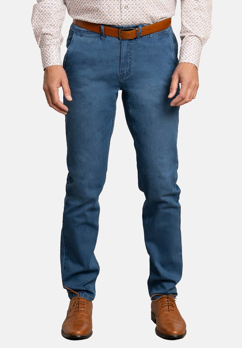 Pantalones de mezclilla azul con un corte de pierna recta, que cuentan con un cinturón de cuero marrón y zapatos de cuero marrón, exhibidos sobre un fondo neutral.