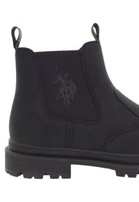 Černé chelsea boty s silnou gumovou podrážkou, elastickým bočním panelem, poutky na patě a vyraženým logem póla na boku.