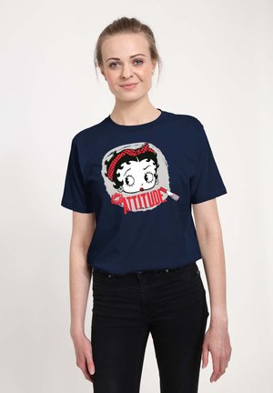 Marineblå bomulds-T-shirt med et grafik af en karakter med et rødt prikket pandebånd og ordet "ATTITUDE" i fede røde bogstaver.