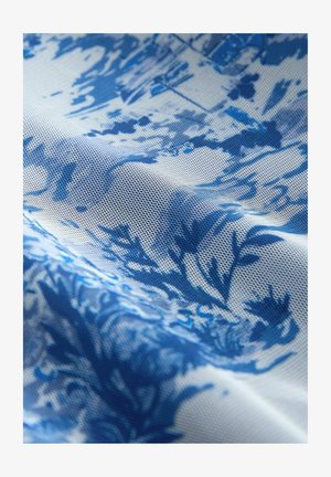 Blau-weiß gemusteter Stoff mit strukturierter Oberfläche, der abstrakte Blumen- und Blattmotive auf einem texturierten Hintergrund zeigt.