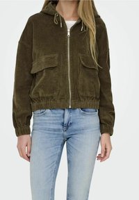 Olivgrön kordfl succulent jacka med huva, silverfärgad framdragkedja, elastiska ärmslut och två fickor framtill. Har en kortad design.