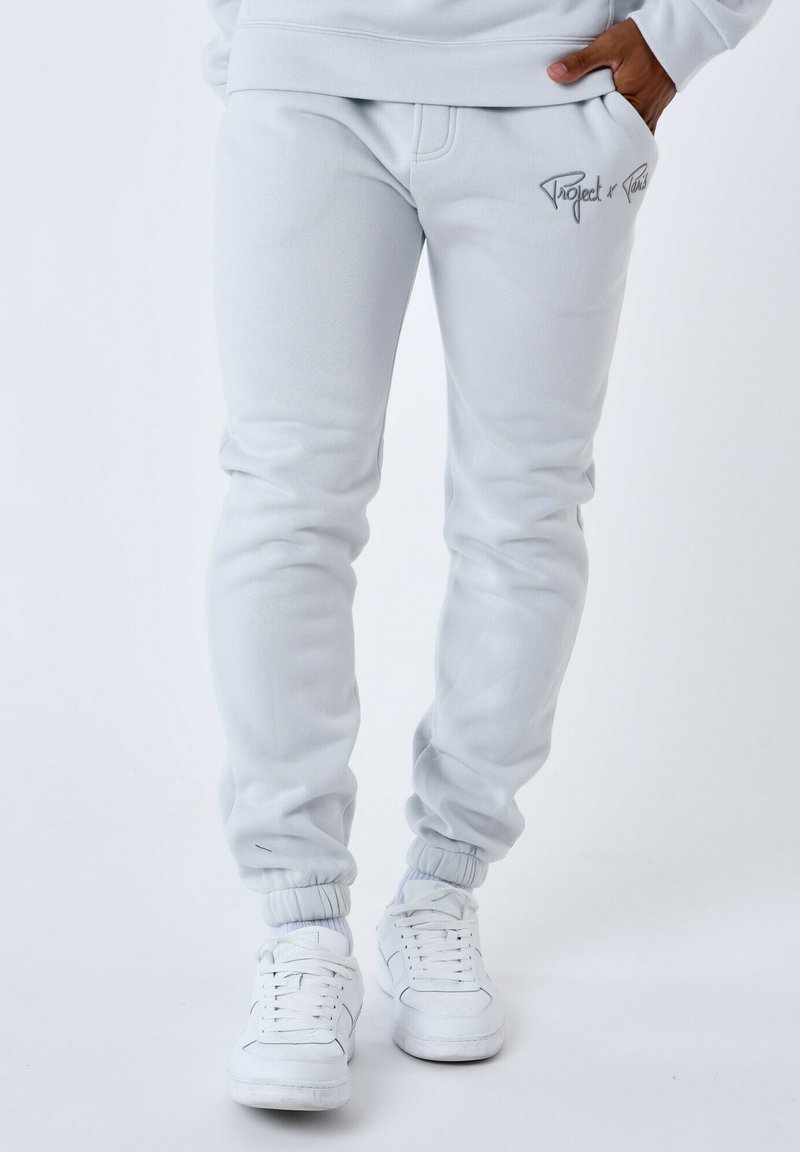 Lichtgrijze sweatpants van zachte stof, met een slim fit, elastische boorden en een subtiel logo-detail aan de voorkant.