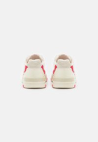 Sneakers with a cream fabric upper, pink accents on the sides and soles, and a textured back panel. Rounded toe design and low profile.