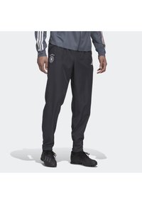 Sorte sportbukser med elastisk talje, prydet med det tyske landsmandskabs emblem og 3 hvide Adidas-striber ned ad siderne.