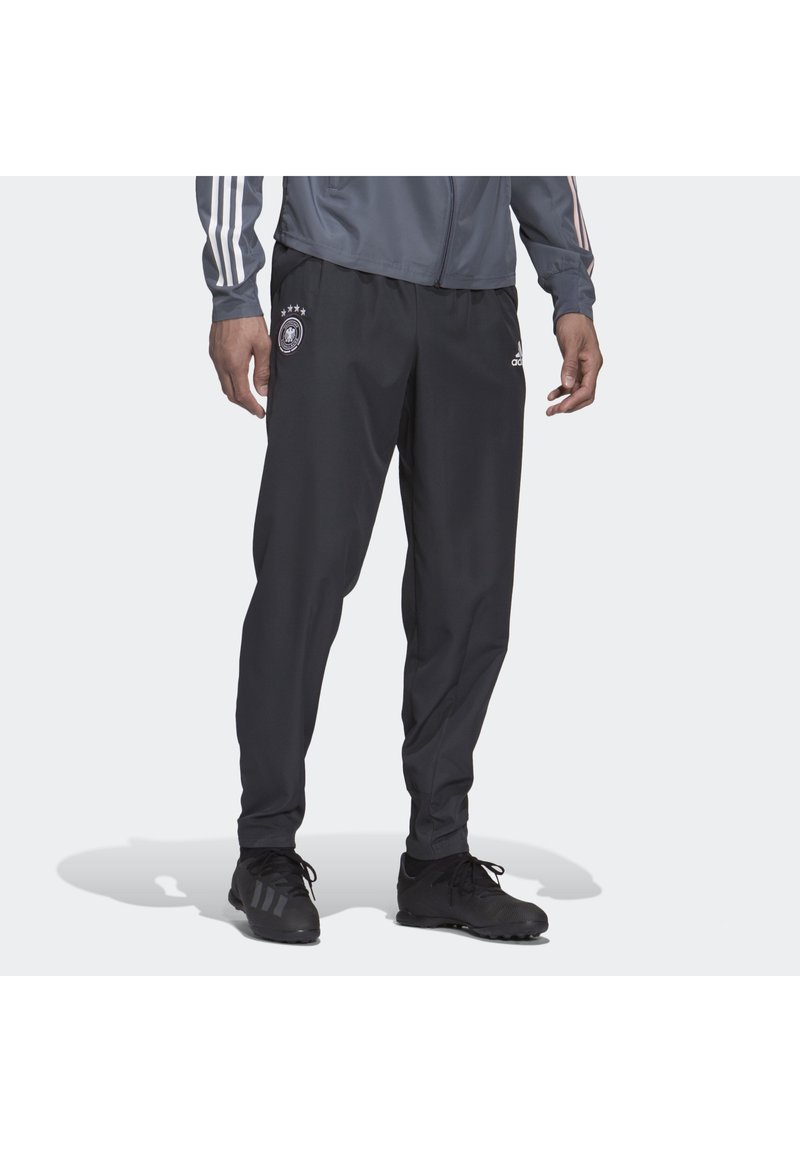 Sorte sportbukser med elastisk talje, prydet med det tyske landsmandskabs emblem og 3 hvide Adidas-striber ned ad siderne.