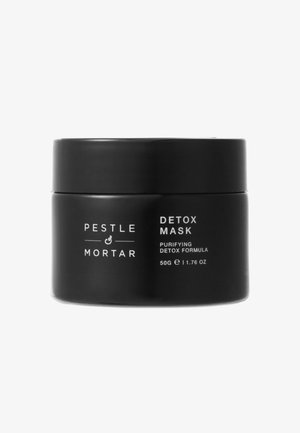 Black cylindrical jar with a matte finish, labeled "Detox Mask," containing 50g of purifying detox formula.