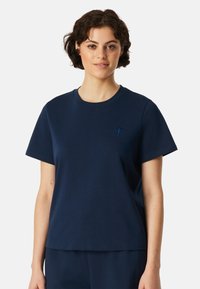 Marineblaues T-Shirt mit kurzen Ärmeln aus weichem Baumwollmaterial, mit rundem Halsausschnitt und kleinem gesticktem Logo auf der Brust.