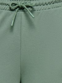 Pantalon de survêtement vert avec un tissu doux et texturé. Taille élastique avec cordon de serrage et embouts en plastique. Design simple et minimaliste sans poches.