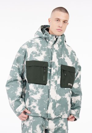 Veste à capuche avec un motif de nuages vert et blanc, deux poches poitrine zippées et une coupe décontractée. Le matériau semble résistant aux intempéries.