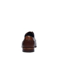Chaussures en cuir marron avec une finition texturée, dotées d'un petit talon et d'une pointe ronde. L'arrière présente des détails de couture et une texture lisse.