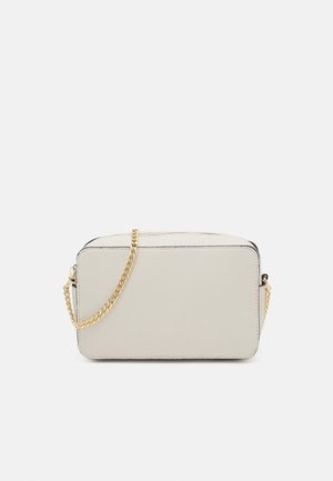 Sac à main rectangulaire en cuir crème avec une finition texturée. Dispose d'une bandoulière chaîne dorée et d'un liseré noir le long des bords. Fermeture zippée sur le dessus.