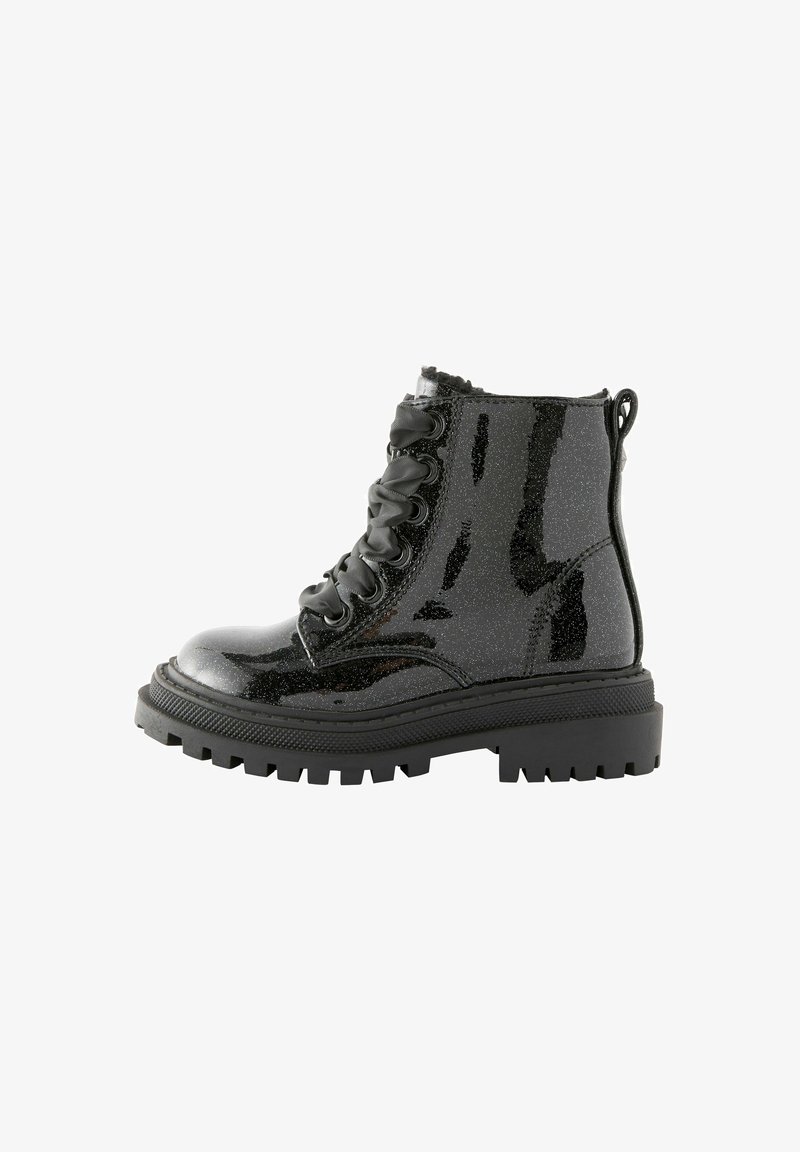 Botte de combat noire brillante avec semelle épaisse à crampons et lacets en ruban de satin, vue de côté sur fond blanc.