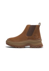 Bruna mockaskinn Chelsea-boots med elastiska sidopaneler och en dragflik. Tjock gummisula med djupa spår för bättre grepp. Logotyp präglad på sidan.